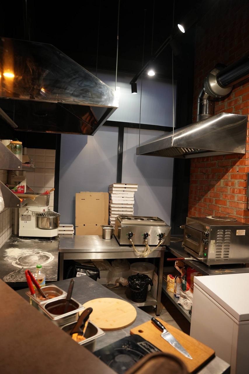 Рабочая зона кухни с вытяжками и печью для пиццы